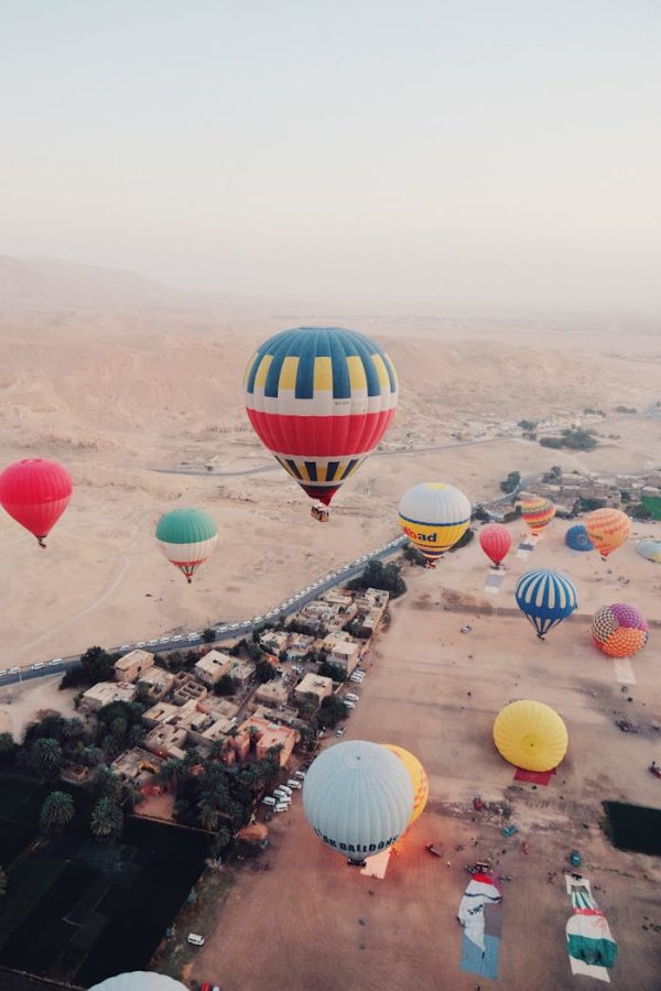 Hot Air Balloons Flying over an Edge of a Desert City